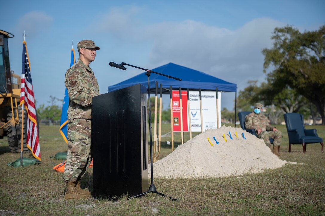 A uniformed member stands at a podium