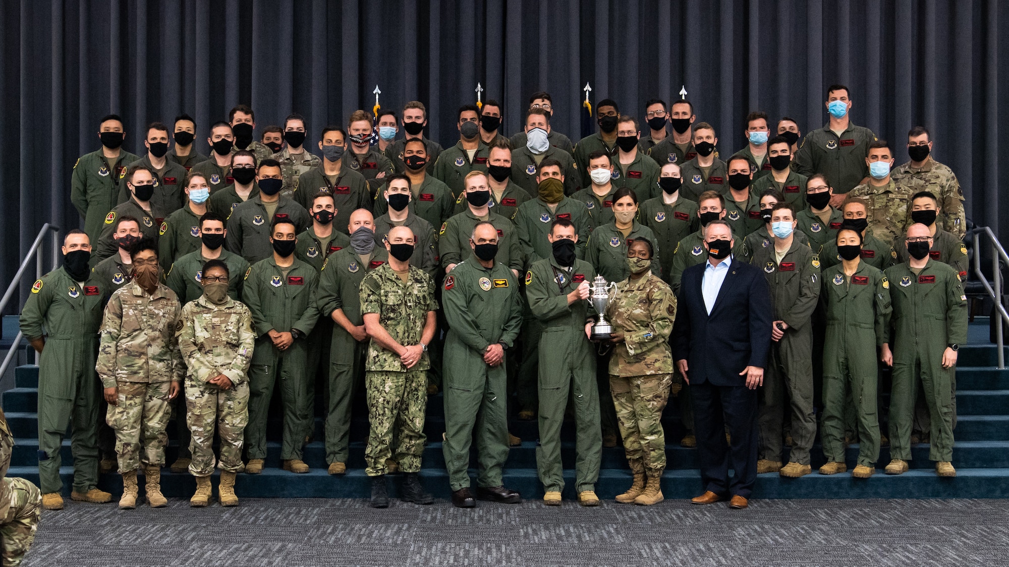 Leaders from U.S. Strategic Command, Strategic Command Consultation Committee and Airmen from the 96th Bomb Squadron pose for a photo with the Omaha Trophy at Barksdale Air Force Base, Louisiana, March 30, 2021. The Omaha Trophy is awarded each year to various units in recognition of outstanding support to USSTRATCOM's strategic deterrence mission. (U.S. Air Force photo by Airman 1st Class Jacob B. Wrightsman)