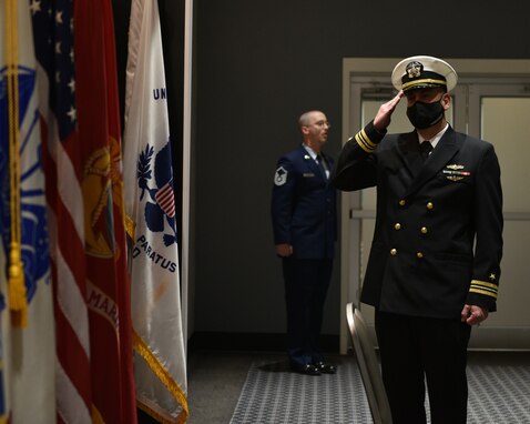 U.S. Navy Lt. Cmdr. Mark Wess, Navy Center for Information Warfare Training Detachment Goodfellow officer in charge, salutes the American flag during the Change of Charge ceremony at the Event Center on Goodfellow Air Force Base, Texas, March 31, 2021. This change of charge was a formal and distinguished ceremony, designed to show respect for authority. (U.S. Air Force photo by Senior Airman Ashley Thrash)