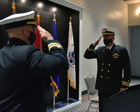 U.S. Navy Lt. Cmdr. John Allen, departing Navy Center for Information Warfare Training Detachment Goodfellow officer in charge, exchanges salutes with Lt. Cmdr. Mark Wess, Navy CIWT Detachment Goodfellow incoming commanding officer, during the Change of Charge ceremony at the Event Center on Goodfellow Air Force Base, Texas, March 31, 2021. This change of charge ceremony was a time to honor military tradition and signified the transfer of authority. (U.S. Air Force photo by Senior Airman Ashley Thrash)