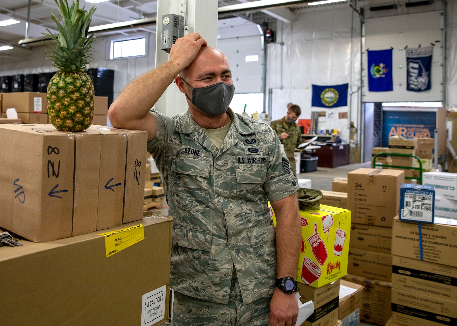 Staff Sgt. Dexter Stone of Task Force Distro, New Hampshire Air National Guard, shares a laugh will fellow Guardsmen March 31, 2021, at a PPE warehouse in Concord, N.H.