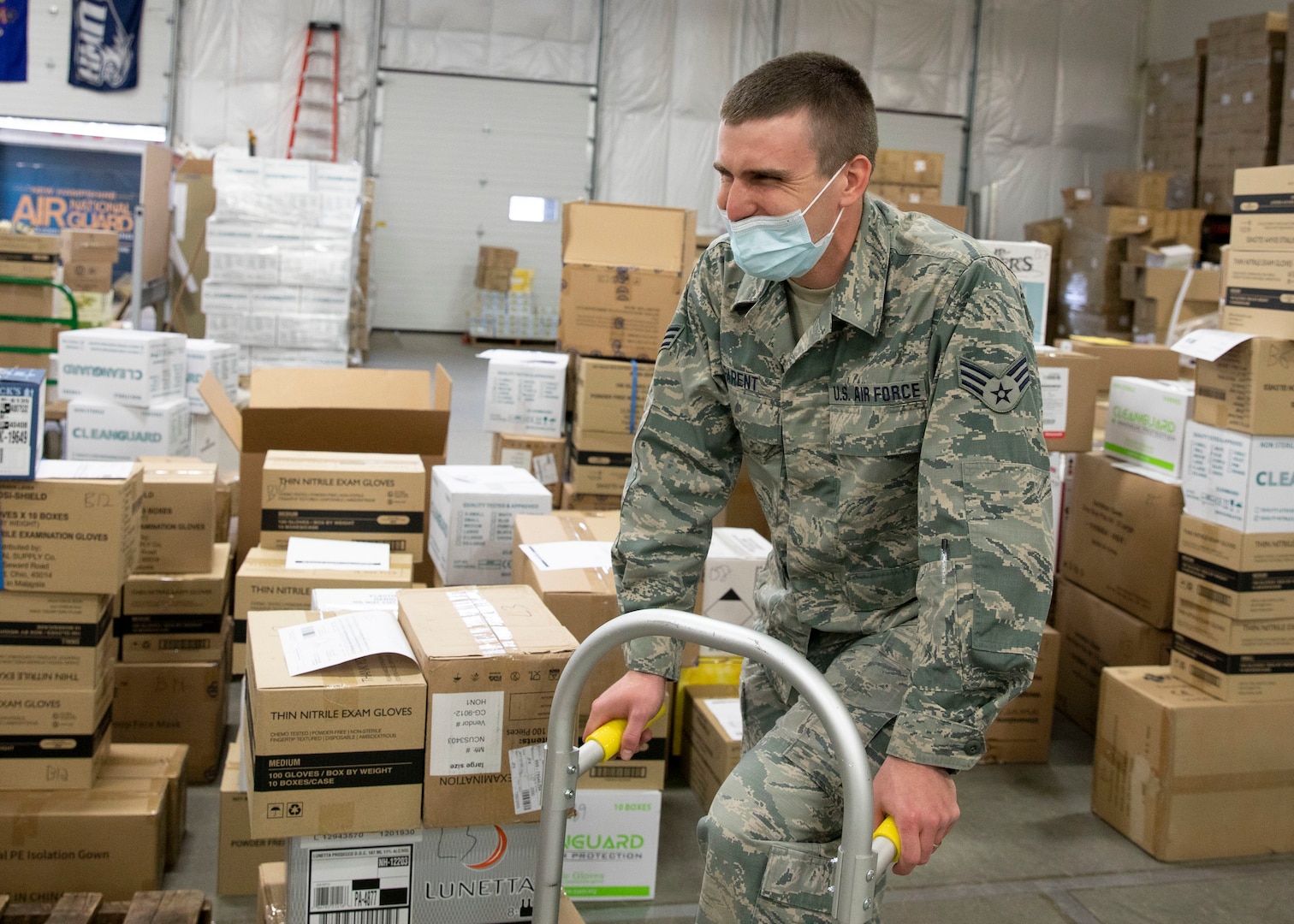 Senior Airman Christopher Parent, an air traffic controller with Pease Air National Guard Base's 260th Air Traffic Control Squadron, New Hampshire Air National Guard, shares a laugh reminiscing about the Airman Battle Uniform (ABU) and the transition to the Army's Operational Camouflage Pattern (OCP) at the state's PPE warehouse March 31, 2021, in Concord, N.H.