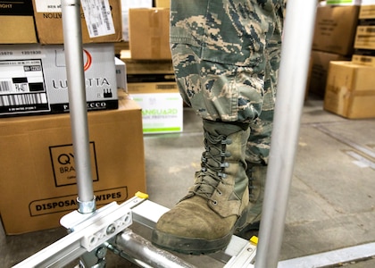 Senior Airman Christopher Parent, an air traffic controller with Pease Air National Guard Base's 260th Air Traffic Control Squadron, New Hampshire Air National Guard, shows off his sage green boots, the official footwear of the decommissioned Airman Battle Uniform, March 31, 2021, in Concord, N.H. The uniform is replaced by the Army's Operational Camouflage Pattern (OCP), which features Coyote brown footwear.