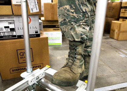 Senior Airman Christopher Parent, an air traffic controller with Pease Air National Guard Base's 260th Air Traffic Control Squadron, New Hampshire Air National Guard, shows off his sage green boots, the official footwear of the decommissioned Airman Battle Uniform, March 31, 2021, in Concord, N.H. The uniform is replaced by the Army's Operational Camouflage Pattern (OCP), which features Coyote brown footwear.