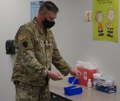 Staff Sgt. Benjamin Kilmer, site noncommissioned officer in charge for the Pennsylvania National Guard vaccination team at Capital Area Intermediate Unit in Enola, Pa., distributes vaccines to the different stations at the site on March 26, 2021.