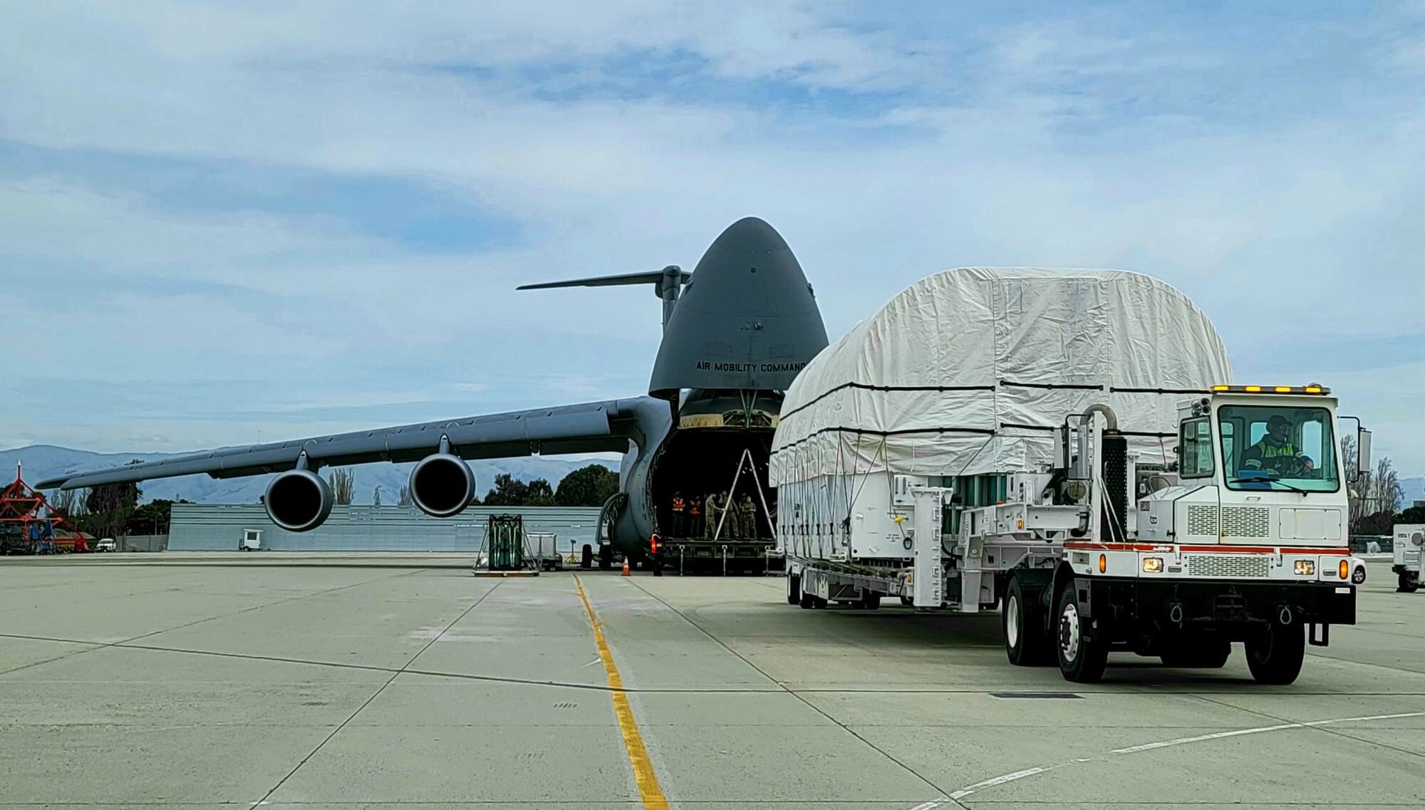 A C-5M Super Galaxy crew from the 60th Air Mobility Wing, Travis Air Force Base, Calif., prepares to front load the SBIRS GEO 5 satellite into the plane’s cargo hold, at Moffett Airfield, Calif., March 17, 2021. The satellite traveled across the country from the Lockheed Martin Space Systems Center satellite integration facility in Sunnyvale, Calif., to the processing facility at Cape Canaveral Space Force Station, Flo. (U.S. Air Force photo by Walter Talens)