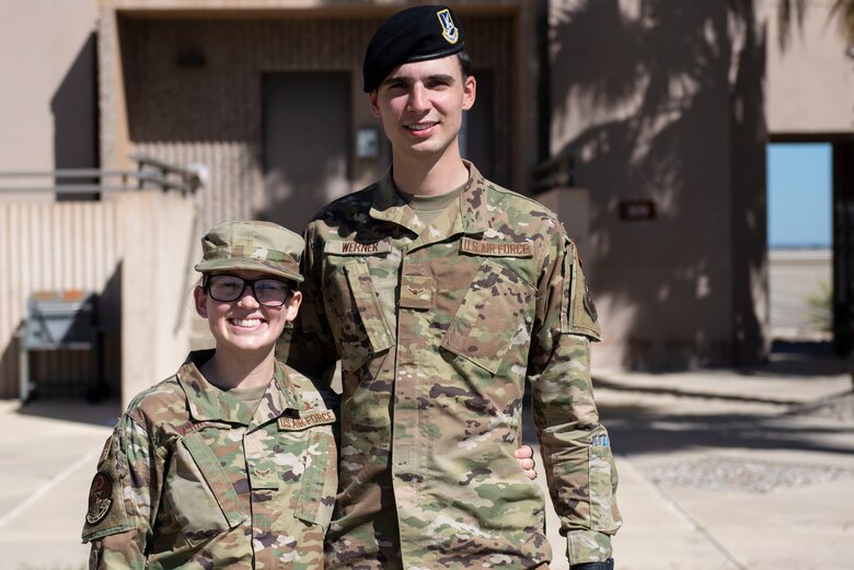 Airman 1st Class Abby Werner 47th Operations Support Squadron air traffic control, and Airman Brinnin Werner 47th Security Forces Squadron installation entry controller, pose together in front of the air traffic control tower at Laughlin Air Force Base, Texas, Feb. 5, 2021. Abby and her husband are both new to the military and face the same hardships that many other mil-to-mil couples must face, being away from each other and family for long periods of time. (U.S. Air Force photo by Airman 1st Class David Phaff)