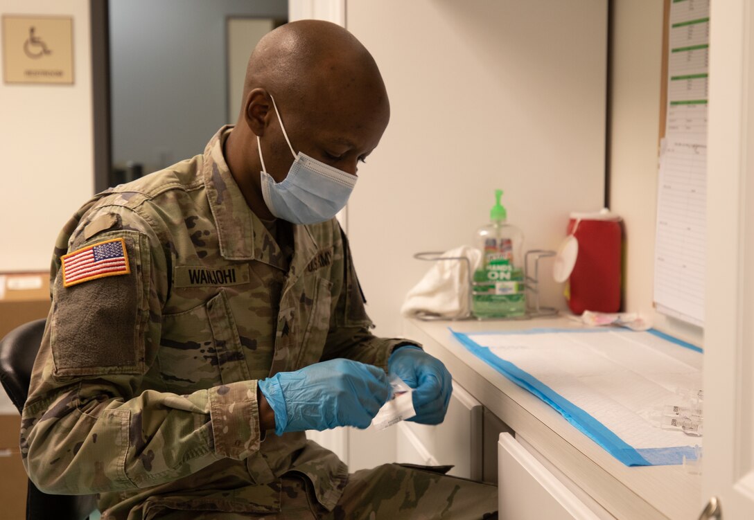 U.S. Army Sgt. Dominic Wanjohi, a Kerugoya, Kenya, native and a medical logistics specialist assigned to the 531st Hospital Center, prepares his pharmacy station at the state-run, federally-supported First Baptist Church of Lincoln Gardens COVID-19 Community Vaccination Center in Somerset, New Jersey, March 26, 2021.