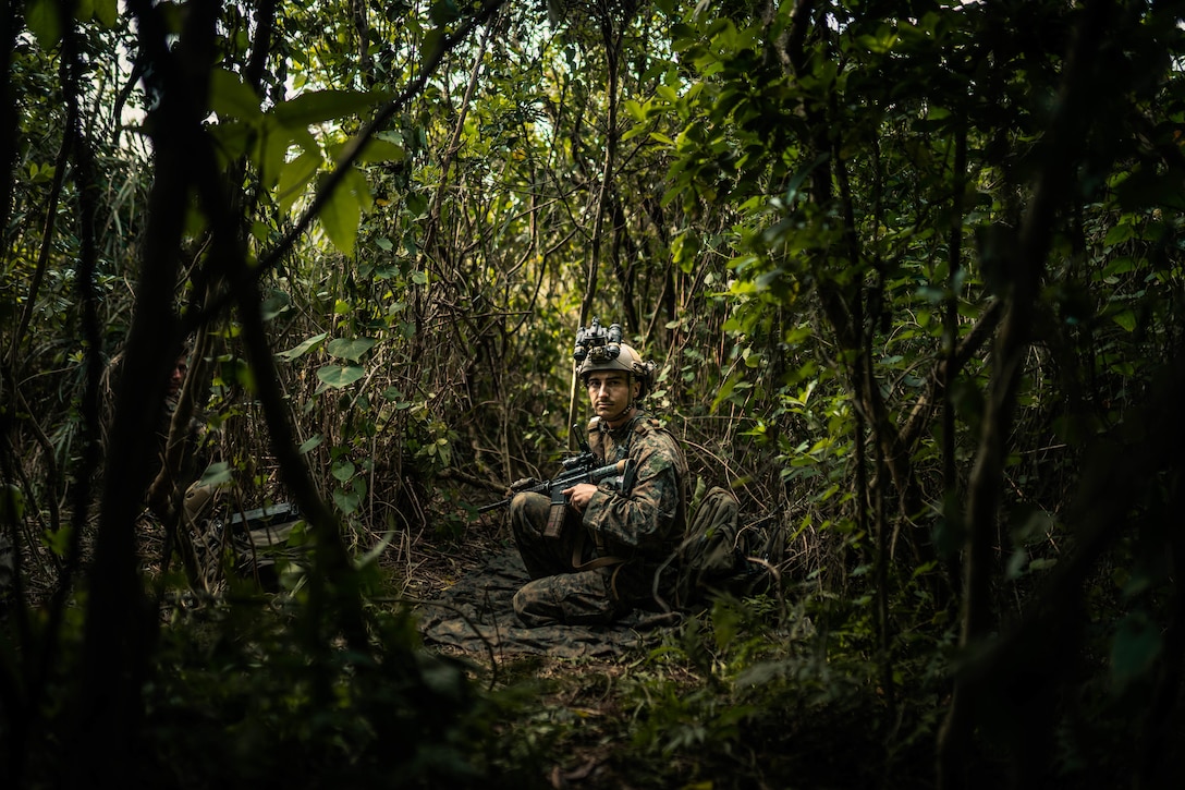 U.S. Marine Corps Sgt. Skyler Sion, a radio operator with 3rd Reconnaissance Battalion, 3rd Marine Division, sets security at a patrol base during Castaway 21.1 on Ie Shima, Okinawa, Japan, March 10, 2021 as a part of Castaway 21.1. The exercise demonstrated the Marine Corps’ ability to integrate with the joint force to seize and defend key maritime terrain, provide low-signature sustainment, and execute long-range precision fires in support of naval operations from an expeditionary advanced base.