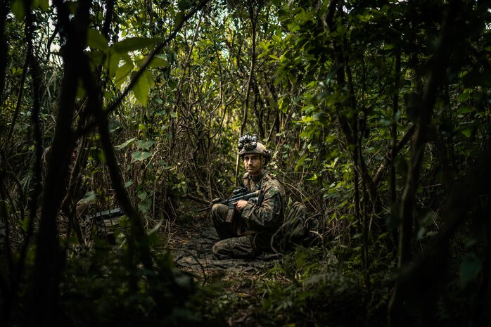 U.S. Marine Corps Sgt. Skyler Sion, a radio operator with 3rd Reconnaissance Battalion, 3rd Marine Division, sets security at a patrol base during Castaway 21.1 on Ie Shima, Okinawa, Japan, March 10, 2021 as a part of Castaway 21.1. The exercise demonstrated the Marine Corps’ ability to integrate with the joint force to seize and defend key maritime terrain, provide low-signature sustainment, and execute long-range precision fires in support of naval operations from an expeditionary advanced base.