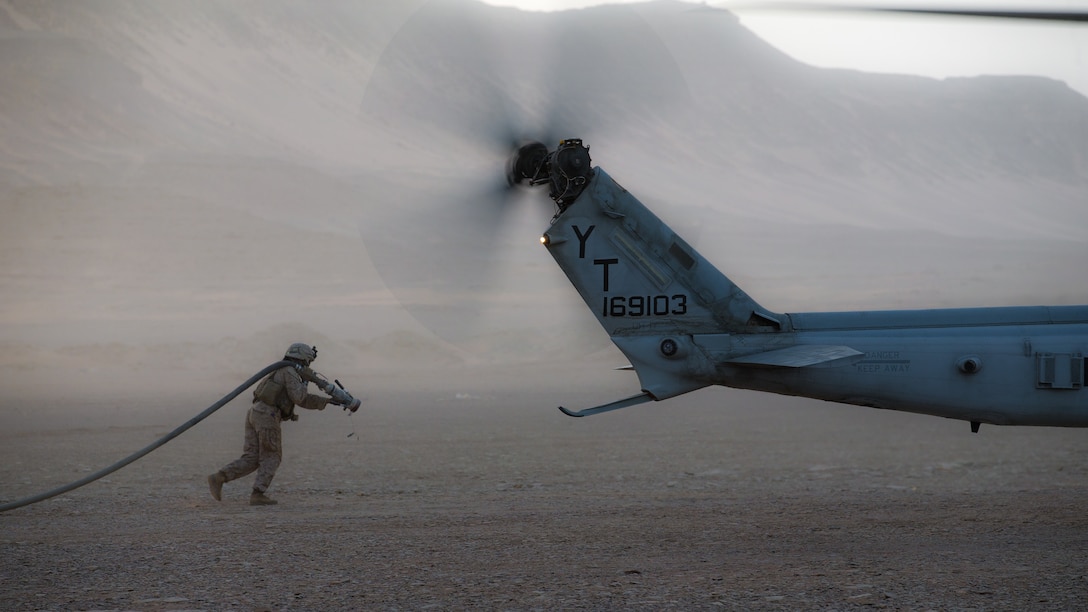 U.S. Marine Corps Cpl. Selina Lopez, a radio operator assigned to Marine Medium Tiltrotor Squadron 164 (Reinforced), 15th Marine Expeditionary Unit, carries a fuel hose to a UH-1Y Venom at a forward arming and refueling point during a theater amphibious combat rehearsal in Tabuk, Kingdom of Saudi Arabia, March 9, 2021. TACR integrates U.S. Navy and Marine Corps assets to practice and rehearse a range of critical combat-related capabilities available to U.S. Central Command, both afloat and ashore, to promote stability and security in the region. The 15th MEU is deployed to the U.S. 5th Fleet area of operations in support of naval operations to ensure maritime stability and security in the Central Region, connecting the Mediterranean and Pacific through the Western Indian Ocean and three strategic choke points.