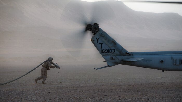 U.S. Marine Corps Cpl. Selina Lopez, a radio operator assigned to Marine Medium Tiltrotor Squadron 164 (Reinforced), 15th Marine Expeditionary Unit, carries a fuel hose to a UH-1Y Venom at a forward arming and refueling point during a theater amphibious combat rehearsal in Tabuk, Kingdom of Saudi Arabia, March 9, 2021. TACR integrates U.S. Navy and Marine Corps assets to practice and rehearse a range of critical combat-related capabilities available to U.S. Central Command, both afloat and ashore, to promote stability and security in the region. The 15th MEU is deployed to the U.S. 5th Fleet area of operations in support of naval operations to ensure maritime stability and security in the Central Region, connecting the Mediterranean and Pacific through the Western Indian Ocean and three strategic choke points.