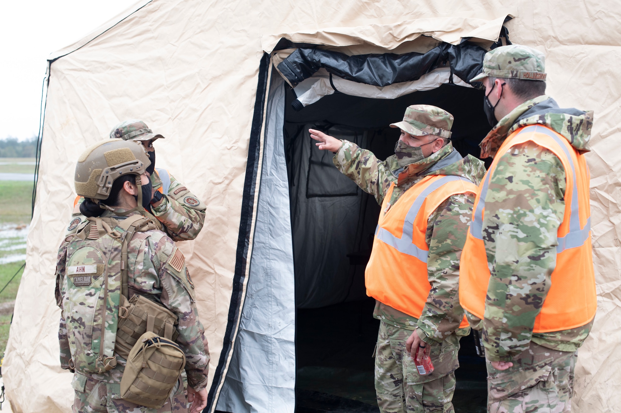 Observers, in orange vests, talk with exercise participants March 25, 2021, during Exercise Turbo Distribution 21-2 at Camp Shelby, Mississippi. Turbo Distribution is a joint task force port opening aerial port of debarkation field training exercise that was held March 24-31. Participating units included the 621st Contingency Response Group stationed at Joint Base McGuire-Dix-Lakehurst, New Jersey, and the U.S. Army 688th Rapid Port Opening Element stationed at Joint Base Langley-Eustis. (U.S. Air Force photo by Tech. Sgt. Luther Mitchell)