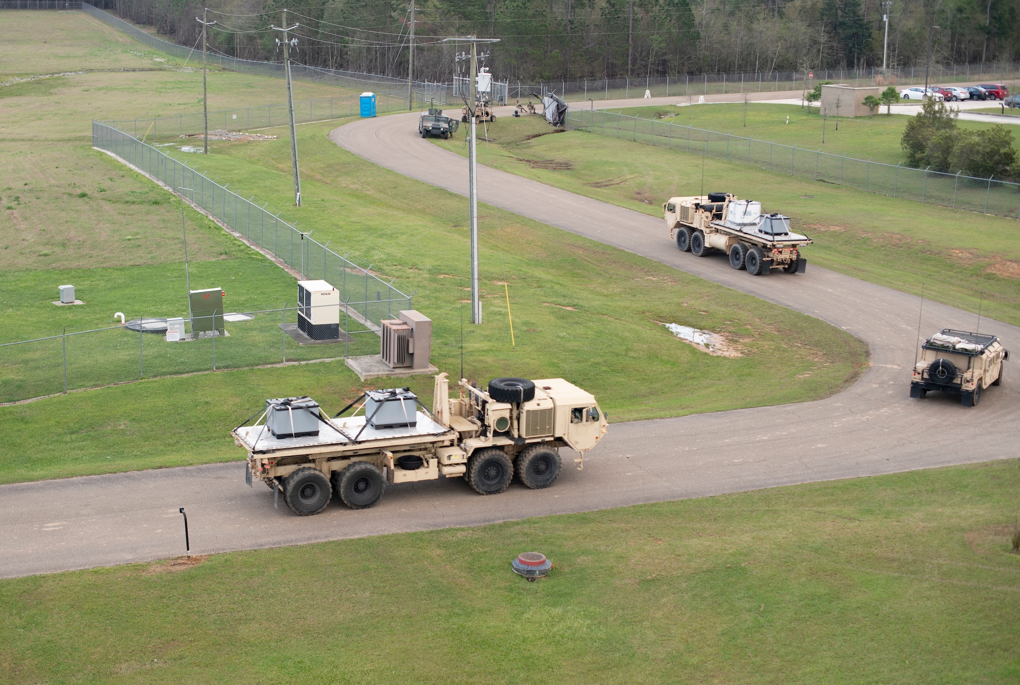 Trucks carrying pallets of simulated relief supplies depart for the forward operating base March, 26, 2021, during Exercise Turbo Distribution 21-2 at Camp Shelby, Mississippi. For Exercise Turbo Distribution, the U.S. Transportation Command established a joint task force port opening aerial port of debarkation capability to respond to a simulated humanitarian aid and disaster relief request from the fictional country of Bengalia. (U.S. Air Force photo by Tech. Sgt. Luther Mitchell)