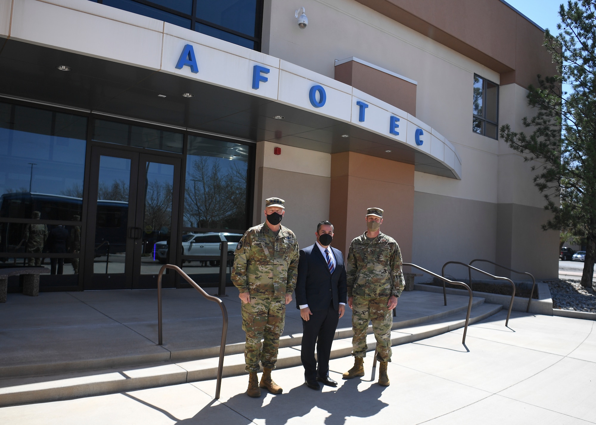 3 men standing in front of building