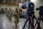 A Soldier with the 345th Combat Sustainment Support Battalion gives a "thumbs up" gesture to cameras broadcasting a virtual send-off ceremony at the National Guard armory in Ada, Oklahoma, April 1, 2021. The Soldiers are being mobilized to Fort Bliss, Texas in order to provide COVID mitigation support to units deploying overseas. (Oklahoma National Guard photo by Leanna Maschino)