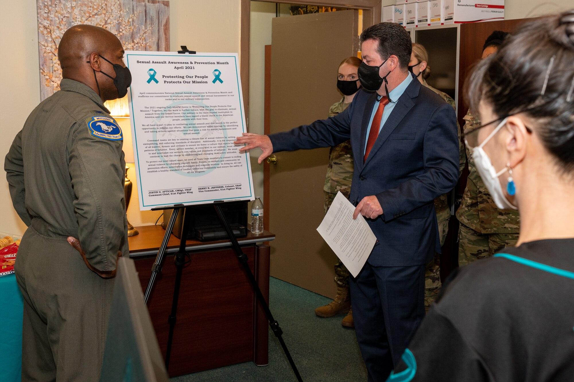 U.S. Air Force Col. Henry Jeffress, 51st Fight Wing vice commander, left, and Richard Coyle, 51st Fighter Wing Sexual Assault Prevention and Response program manager, right, review the SAPR proclamation at Osan Air Base, Republic of Korea, April 1, 2021. The Department of Defense observes Sexual Assault Awareness and Prevention Month by focusing on creating and cultivating a culture to eliminate sexual assault. (U.S. Air Force photo by Senior Airman Branden Rae)