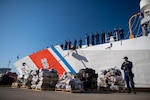The crew of the Coast Guard Cutter Munro gather in formation behind seized contraband during a drug offload in Alameda, California, March 23, 2021. Munro is one of four National Security Cutters homeported in Alameda. These Legend class cutters are 418-feet long, 54-feet wide, and have a 4,600 long-ton displacement. They have a top speed in excess of 28 knots, a range of 12,000 nautical miles, endurance of up to 90 days and can hold a crew of nearly 150. (U.S. Coast Guard photo by Petty Officer 3rd Class Taylor Bacon)