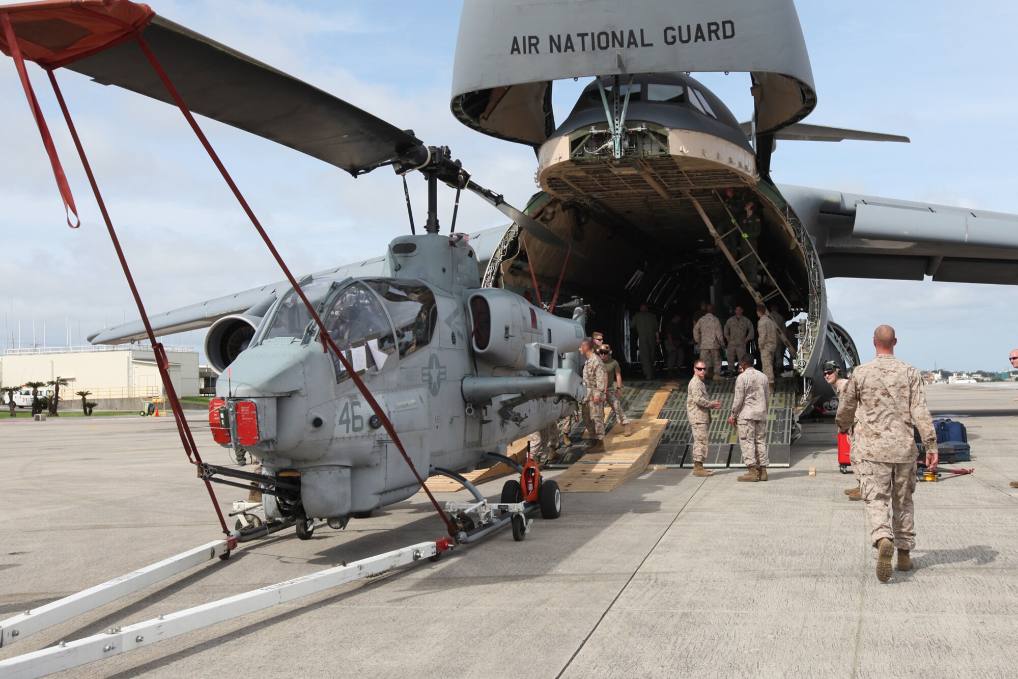 Marines from Marine Heavy Helicopter Squadron 772 (HMH-772) off load an AH-1U Cobra from a C-5 Galaxy on Marine Corps Air Station Futenma, Okinawa, Japan, June 7, 2013. The C-5 was carrying aircraft and personnel from HMH-772. HMH-772 is participating in the Unit Deployment Program. (U.S. Marine Corps photo by Lance Cpl. Jeraco Jenkins/ Cleared For Public Release).