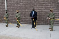 Capt. Tres Meek, commanding officer, Naval Facilities Engineering Systems Command Mid-Atlantic (far left); Capt. Vince Baker, commanding officer, Naval Station (NAVSTA) Norfolk (left); Lloyd Young, Project Manager for Tazewell Contracting (right); and Capt. Dianna Wolfson, commander, Norfolk Naval Shipyard (far right) participate in a ribbon-cutting ceremony to officially present the new Submarine Universal Modular Mast (UMM) Maintenance Tower onboard NAVSTA Norfolk, March 31. The new facility allows the Navy to provide repairs and maintenance for Hampton Roads-based submarines to the UMM, which is an integrated system that houses the submarine’s periscope, antennas and sensors.