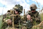 Army Staff Sgt. Robert Moore (right), with 1st Squadron, 2nd Cavalry Regiment, helps U.K. Army LT. Tom Chapman (left), assigned to the 1st The Queen's Dragoon Guards, set up M18A1 Claymore mine during a multinational claymore training exercise with Battle Group Poland at Bemowo Piskie Training Area, Poland on July 10, 2018.