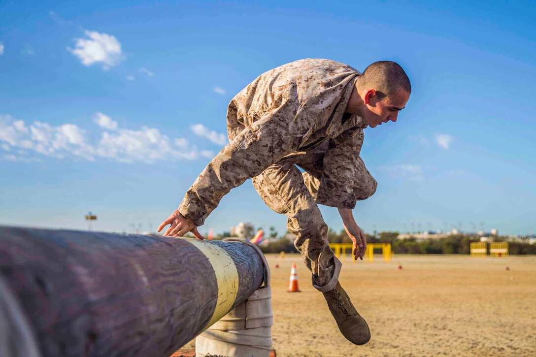 A Marine Corps recruit jumps over an obstacle.