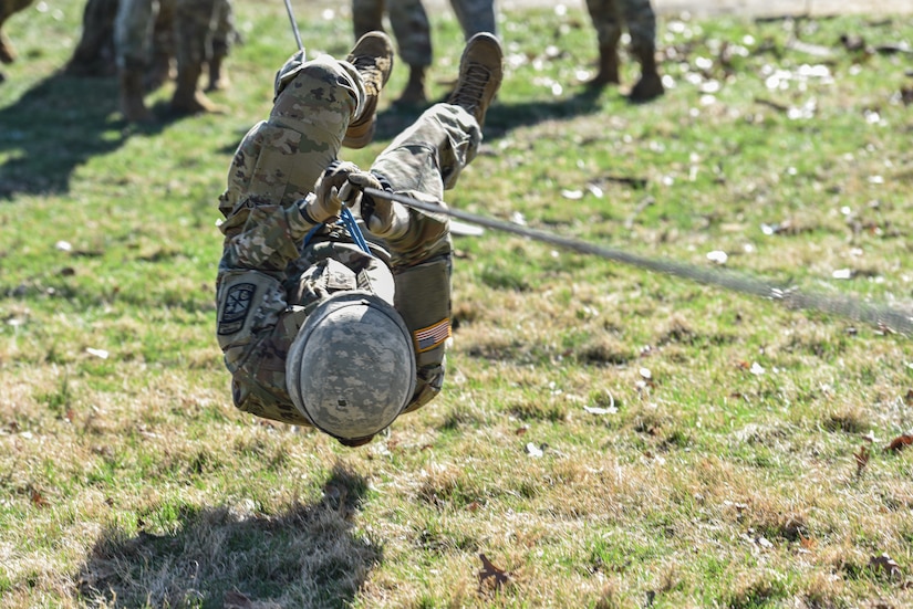 A Reserve Officers' Training Corps cadet tests rope bridge skills during a timed event for the Brigade Ranger Challenge at Joint Base McGuire-Dix-Lakehurst, N.J., March 27, 2021. During this event, cadets must quickly tie and secure a rope between two trees so that team members may cross it without hitting the ground