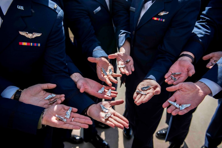 Class 21-06AU graduated April 2 at Vance Air Force Base and soon after, demonstrated a tradition called "breaking of the wings." After breaking the wings, one half stays with the pilot while the other is given to a loved one for safekeeping.