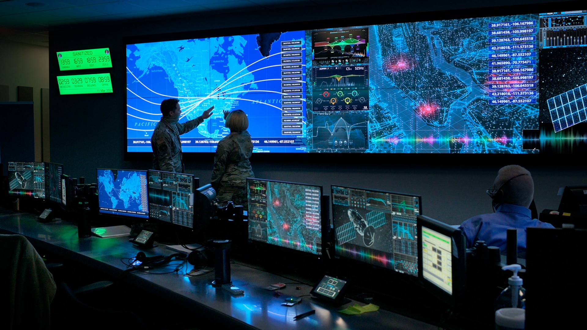 Military personnel stand in an operations center.