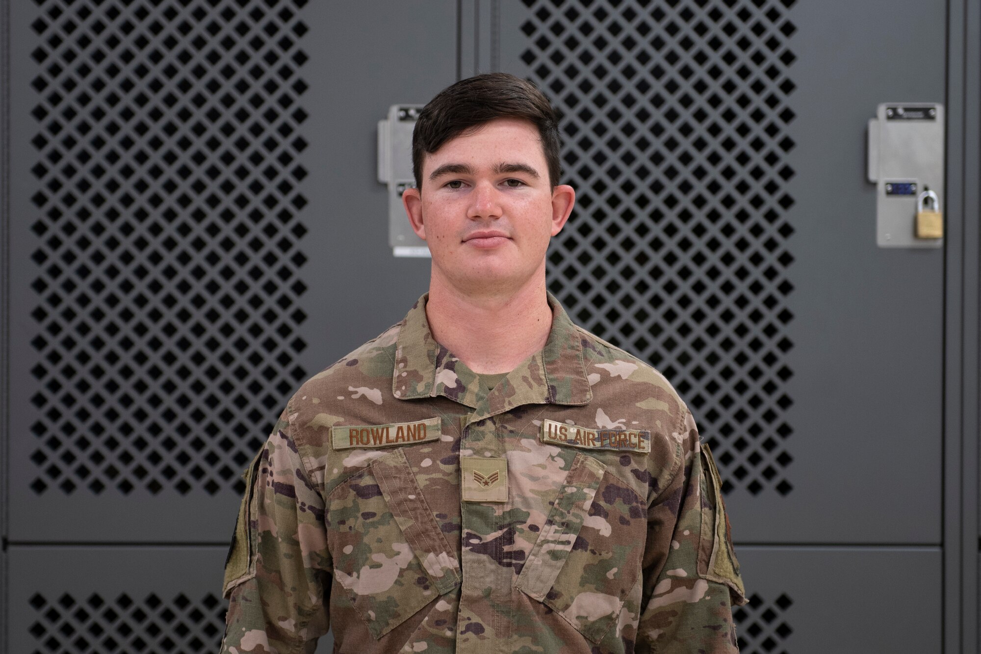 A photo of an Airman standing in front of lockers.