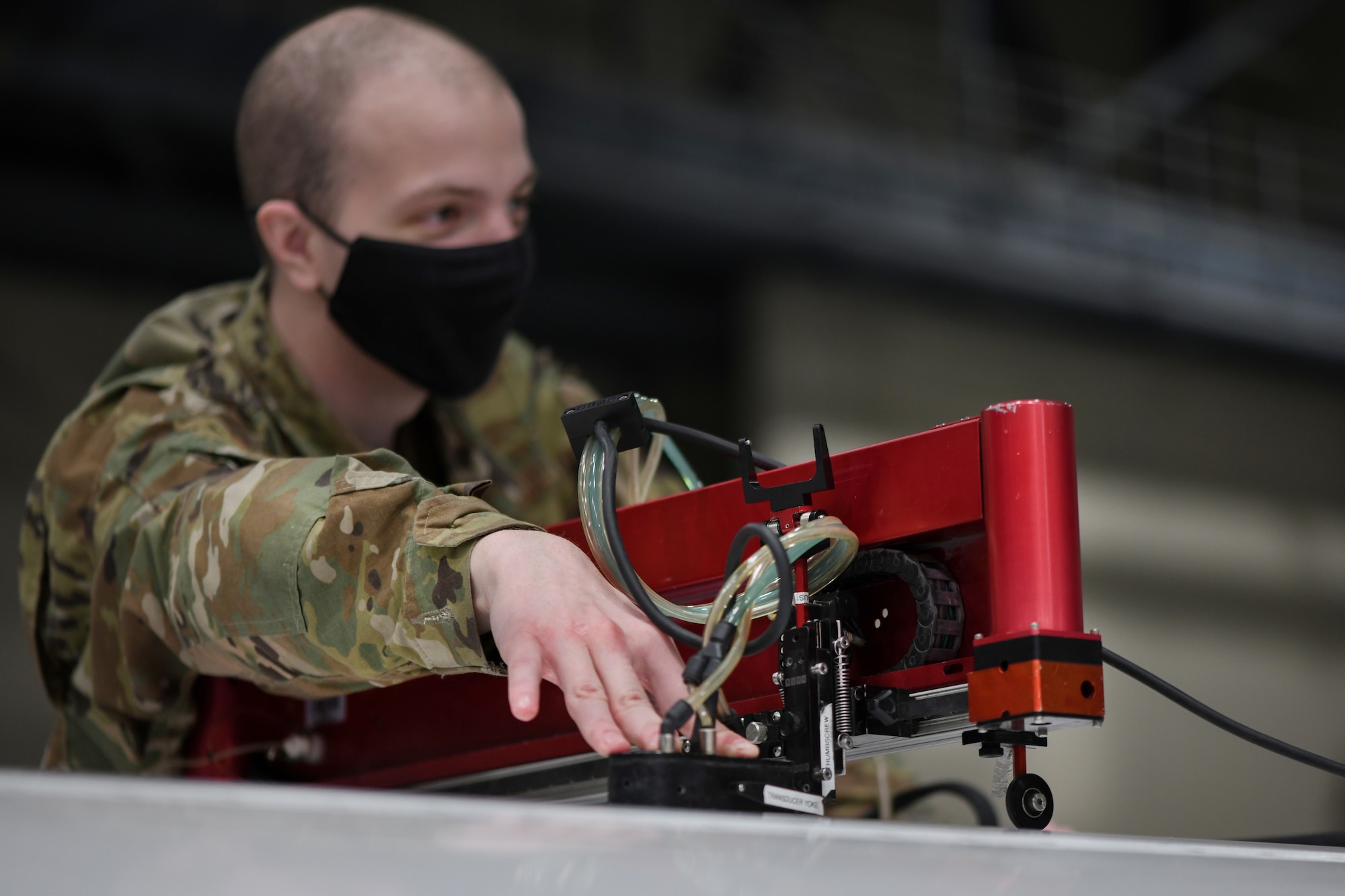 Airman First Class Seth Hardy, 319th Aircraft Maintenance Squadron nondestructive inspection journeyman, scans the wing of an RQ-4 Global Hawk with a mobile automated scanner system on Grand Forks Air Force Base, N.D., March 25, 2021. The MAUS inspection sends sound waves through the wing composite to identify potential defects on the interior of the aircraft. (U.S. Air Force photo by Airman 1st Class Ashley Richards)