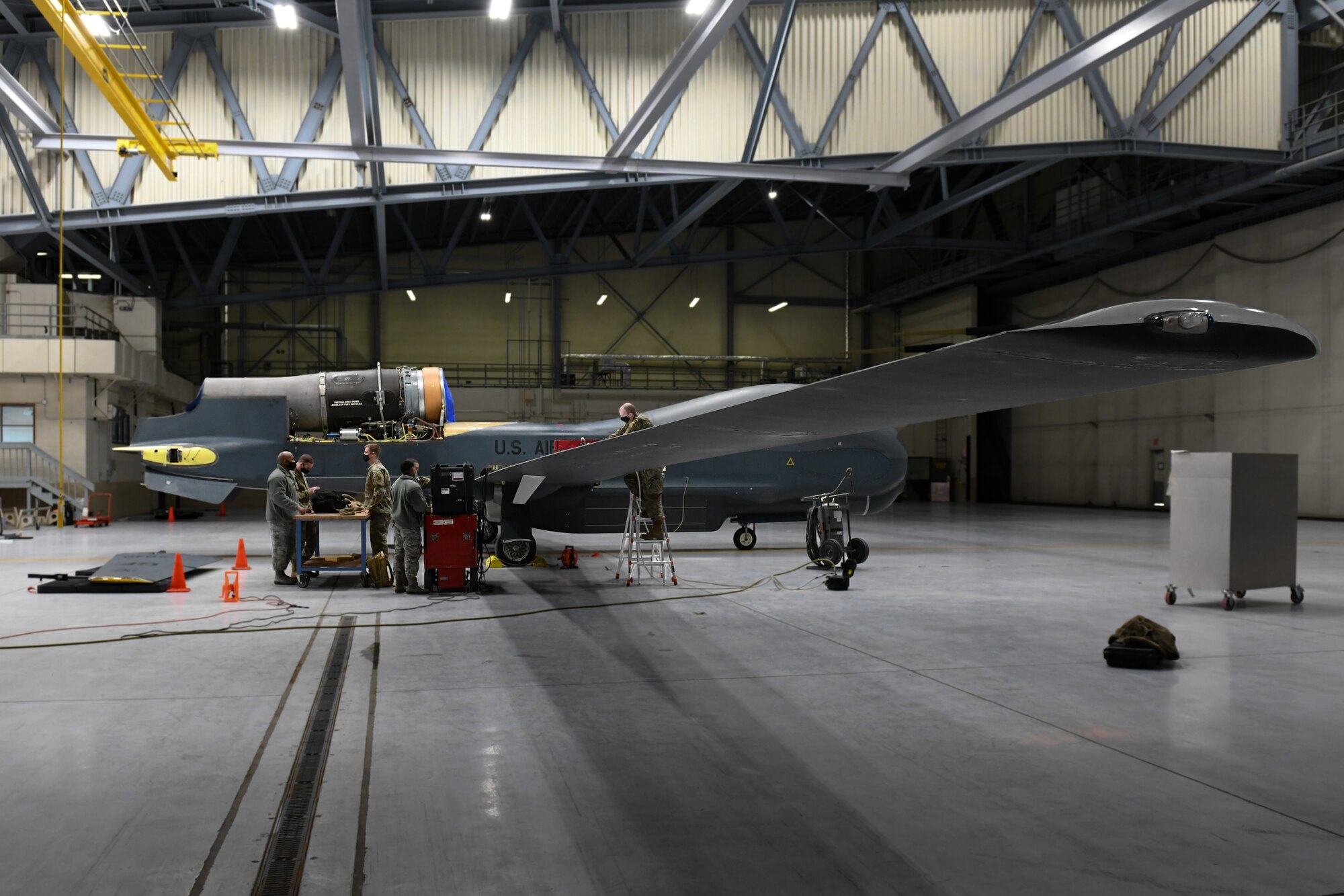 Airmen from the 319th Aircraft Maintenance Squadron nondestructive inspection team work together to complete a mobile automated scan on the wing composite of an RQ-4 Global Hawk at Grand Forks Air Force Base, N.D., March 25, 2021. The 319 AMXS NDI team is the first and only team to travel across the world to perform MAUS inspections on the Global Hawk. (U.S. Air Force photo by Airman 1st Class Ashley Richards)