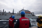 Sailors aboard the Arleigh Burke-class guided-missile destroyer USS Roosevelt (DDG 80) receive pallets of food stores during a replenishment-at-sea with the dry cargo ship USNS William McClean (T-AKE 12), April 1, 2021.