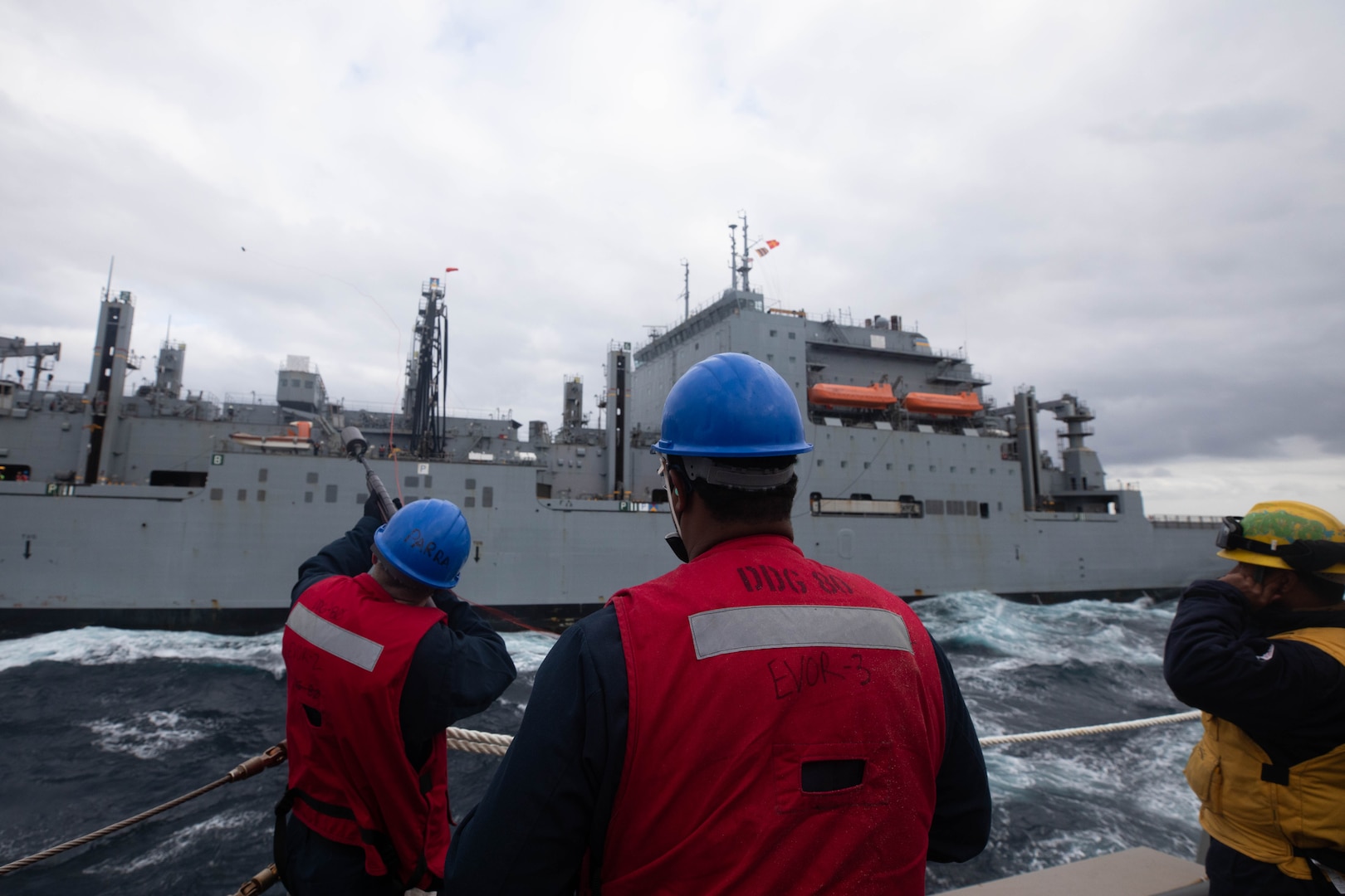 Sailors aboard the Arleigh Burke-class guided-missile destroyer USS Roosevelt (DDG 80) receive pallets of food stores during a replenishment-at-sea with the dry cargo ship USNS William McClean (T-AKE 12), April 1, 2021.