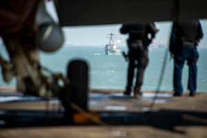 210402-N-TE455-1011 SUEZ CANAL (April 2, 2021) The guided-missile destroyer USS Thomas Hudner (DDG 116) sails behind the aircraft carrier USS Dwight D. Eisenhower (CVN 69) during a transit through the Suez Canal, April 2. The Eisenhower Carrier Strike Group is deployed to the U.S. 5th Fleet area of operations in support of naval operations to ensure maritime stability and security in the Central Region, connecting the Mediterranean and Pacific through the Western Indian Ocean and three strategic choke points. (U.S. Navy photo by Mass Communication Specialist Seaman Apprentice Mo Bourdi)