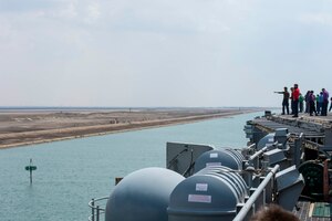 210402-N-VG565-2053 SUEZ CANAL (April 2, 2021) Sailors watch from the flight deck as the aircraft carrier USS Dwight D. Eisenhower (CVN 69) transits the Suez Canal, April 2. The Eisenhower Carrier Strike Group is deployed to the U.S. 5th Fleet area of operations in support of naval operations to ensure maritime stability and security in the Central Region, connecting the Mediterranean and Pacific through the Western Indian Ocean and three strategic choke points. (U.S. Navy photo by Mass Communication Specialist Seaman Aimee Ford)