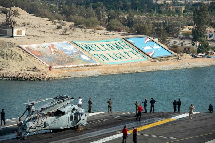 210402-N-FE499-2015 SUEZ CANAL (April 2, 2021) Sailors watch from the flight deck as the aircraft carrier USS Dwight D. Eisenhower (CVN 69) transits the Suez Canal, April 2. The Eisenhower Carrier Strike Group is deployed to the U.S. 5th Fleet area of operations in support of naval operations to ensure maritime stability and security in the Central Region, connecting the Mediterranean and Pacific through the Western Indian Ocean and three strategic choke points. (U.S. Navy photo by Mass Communication Specialist 3rd Class Andrew T. Waters)