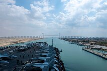 210402-N-GG032-2289 SUEZ CANAL (April 2, 2021) The aircraft carrier USS Dwight D. Eisenhower (CVN 69) approaches the Friendship Bridge during a Suez Canal transit, April 2. The Eisenhower Carrier Strike Group is deployed to the U.S. 5th Fleet area of operations in support of naval operations to ensure maritime stability and security in the Central Region, connecting the Mediterranean and Pacific through the Western Indian Ocean and three strategic choke points. (U.S. Navy photo by Mass Communication Specialist Seaman Orion K. Shotton)