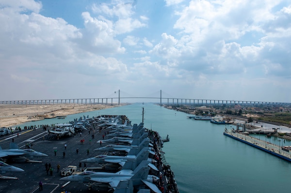 SUEZ CANAL (April 2, 2021) The aircraft carrier USS Dwight D. Eisenhower (CVN 69) approaches the Friendship Bridge during a Suez Canal transit, April 2. The Eisenhower Carrier Strike Group is deployed to the U.S. 5th Fleet area of operations in support of naval operations to ensure maritime stability and security in the Central Region, connecting the Mediterranean and Pacific through the Western Indian Ocean and three strategic choke points. (U.S. Navy photo by Mass Communication Specialist Seaman Orion K. Shotton)