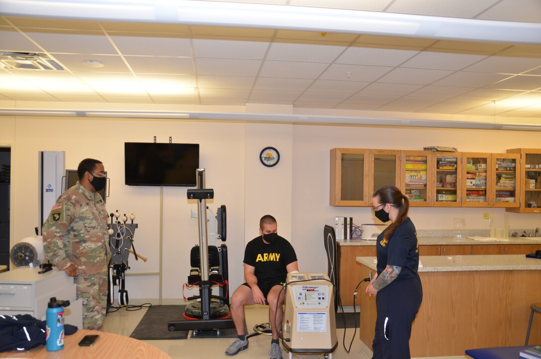 Staff Sgt. William Cox, an Army instructor in the  METC Occupational Therapy Assistant program, observes a student practicing convective thermal therapy, a type of dry heat therapy used to enhance flexibility and circulation while decreasing the need for anti-inflammatory and analgesic medications.