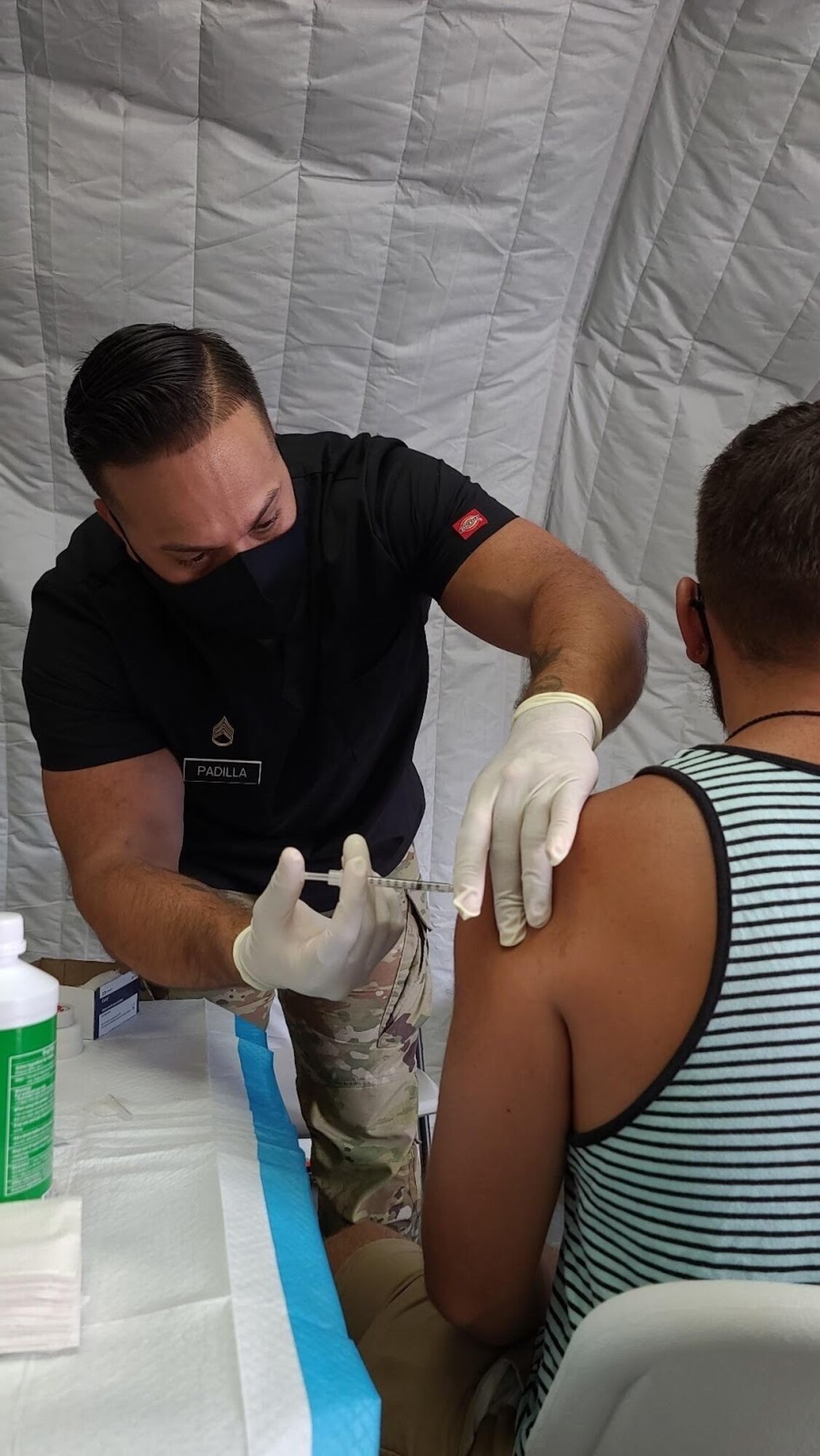 Staff Sgt. Joshua Padilla, assigned to 25th Infantry Division, administers a COVID-19 Vaccine in support of the Commonwealth Healthcare Corporation (CHCC) COVID-19 Vaccination team at the Medical Care and Treatment Site (MCATS).