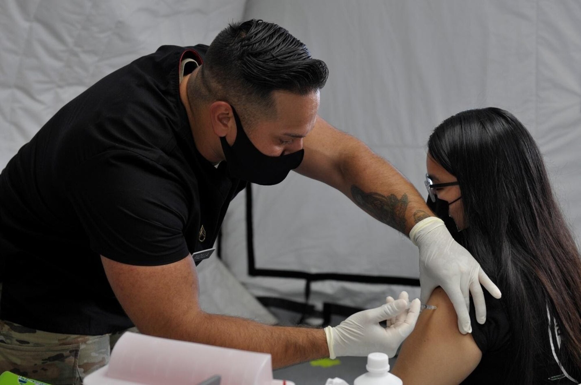 Staff Sgt. Joshua Padilla, assigned to 25th Infantry Division, administers a COVID-19 Vaccine in support of the Commonwealth Healthcare Corporation (CHCC) COVID-19 Vaccination team at the Medical Care and Treatment Site (MCATS).