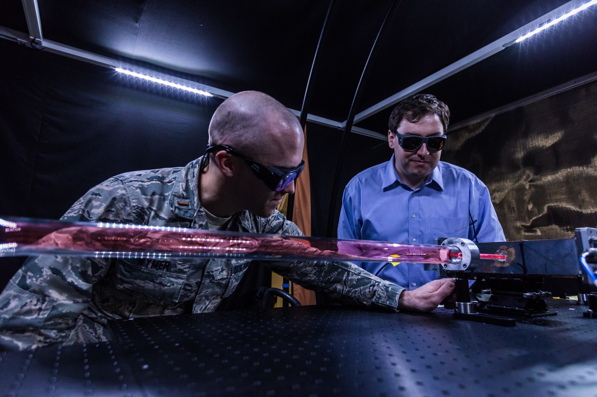 Air Force Research Laboratory physicist 1st Lt. James Wymer tests a laser source in one of the Directed Energy Directorate’s high power microwave labs while fellow researcher Alex Englesbe looks on. (Courtesy photo/AFRL)