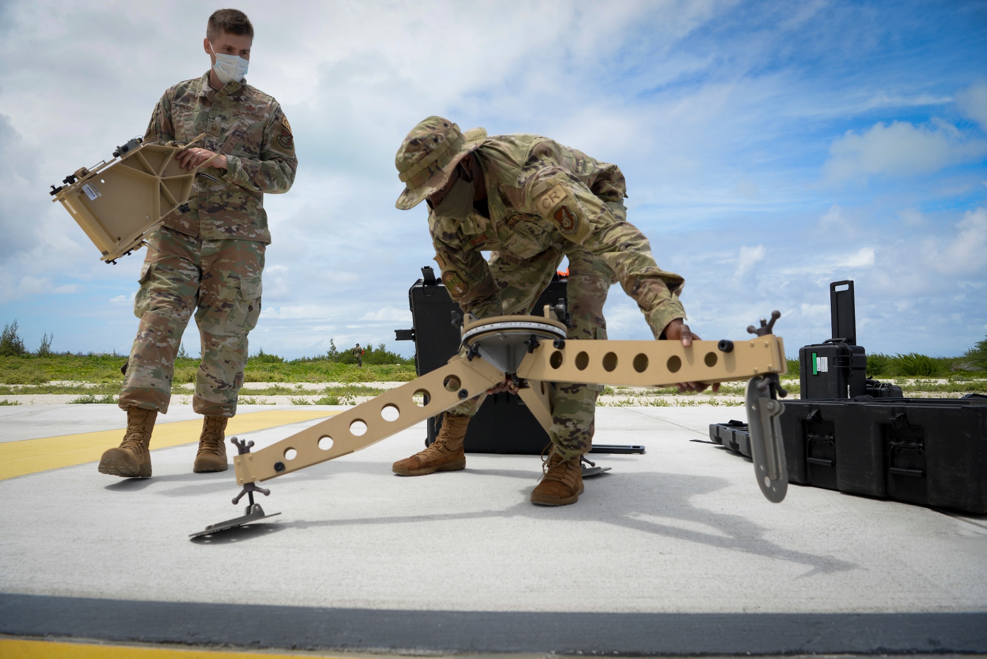 U.S. Air Force Master Sgt. Gilbert Kless, left, and Airman 1st Class Justin Brown, center, assigned to the 644th Combat Communications Squadron, set up a communication fly away kit during a field training exercise on Wake Island, Western Pacific, April 2, 2021.