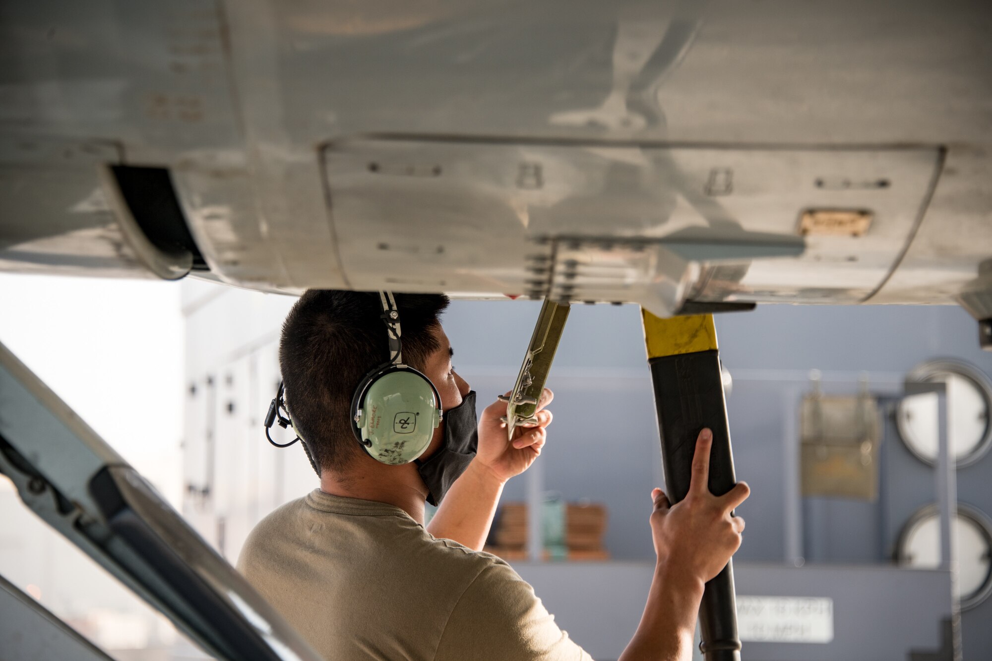 A man plugs in a power cord to an RC-135 Rivet Joint aircraft