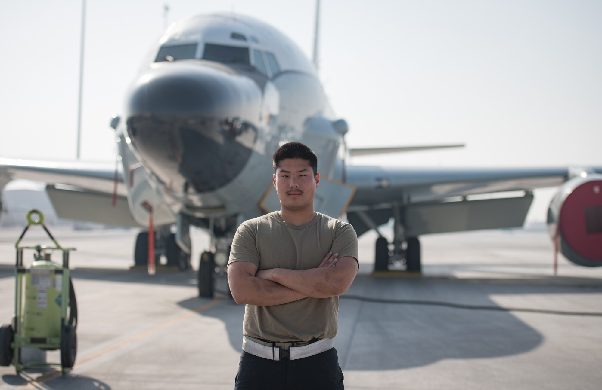 A man poses in front of an RC-135 Rivet Joint aircraft