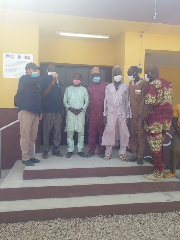 Humanitarian Assistance Program Coordinator Cosme Quenum, a local national with the U.S. Embassy in Cotonou, Benin, turns over the keys of a newly constructed health clinic to local officials in the village of Godjekoara, Benin in Africa at the end of January 2021. The clinic and various associated facilities also built with it comprise one of two similar clinic projects recently completed by the U.S. Army Corps of Engineers in that region of Benin through funding from AFRICOM and coordinated closely with the U.S. State Department.