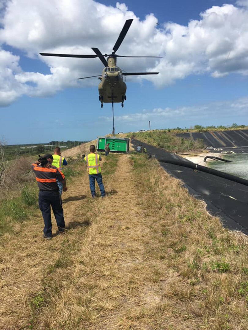 A Florida National Guard CH-47 Chinook helicopter places pumps at the leaking Piney Point Reservoir in Manatee County in the Tampa Bay area April 4, 2021. They placed two pumps at the pond to accelerate efforts to lower the water level enough to repair the leak.