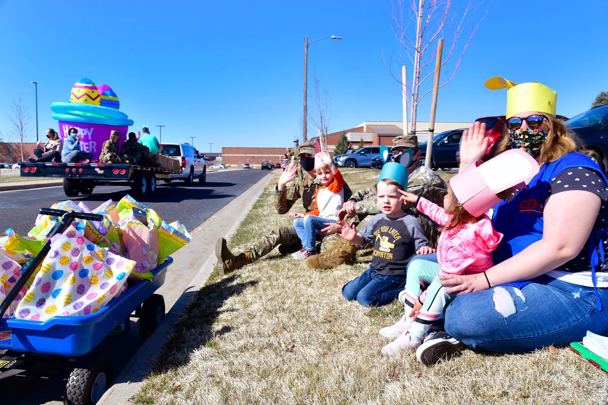 Children and Child Development Center caregivers waving and cheering during the “Operation Bunny Trail” Easter parade.