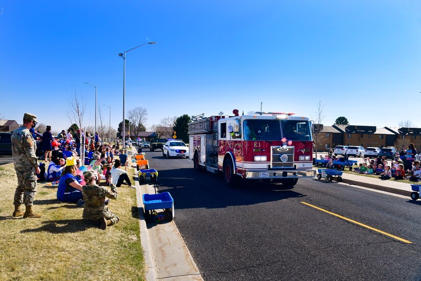 Emergency vehicles sounding sirens and flashing lights as the “Operation Bunny Trail” Easter parade rolls its way to military family housing.